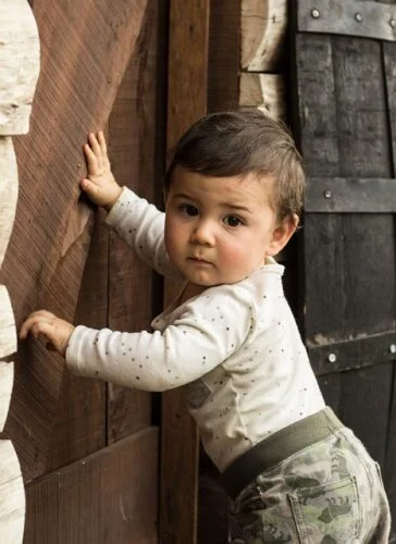 Baby standing against wall