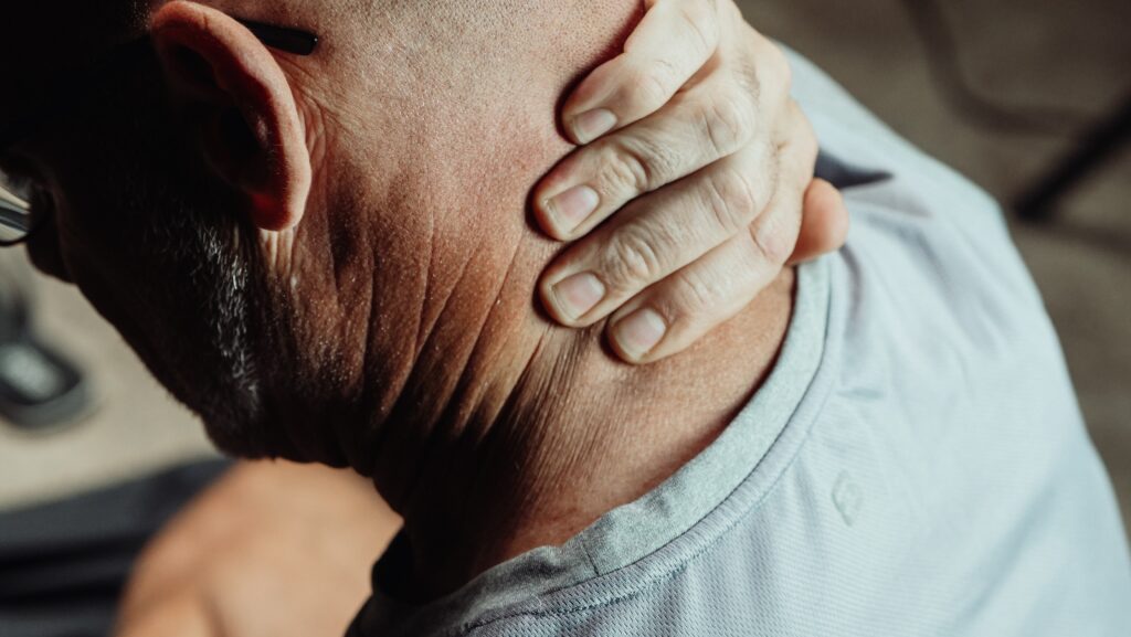 Person holding neck in pain